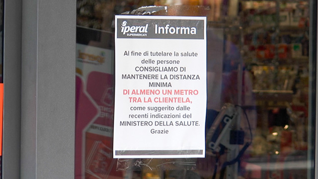 Indicazioni fuori dalla porta di un supermercato di Clusone